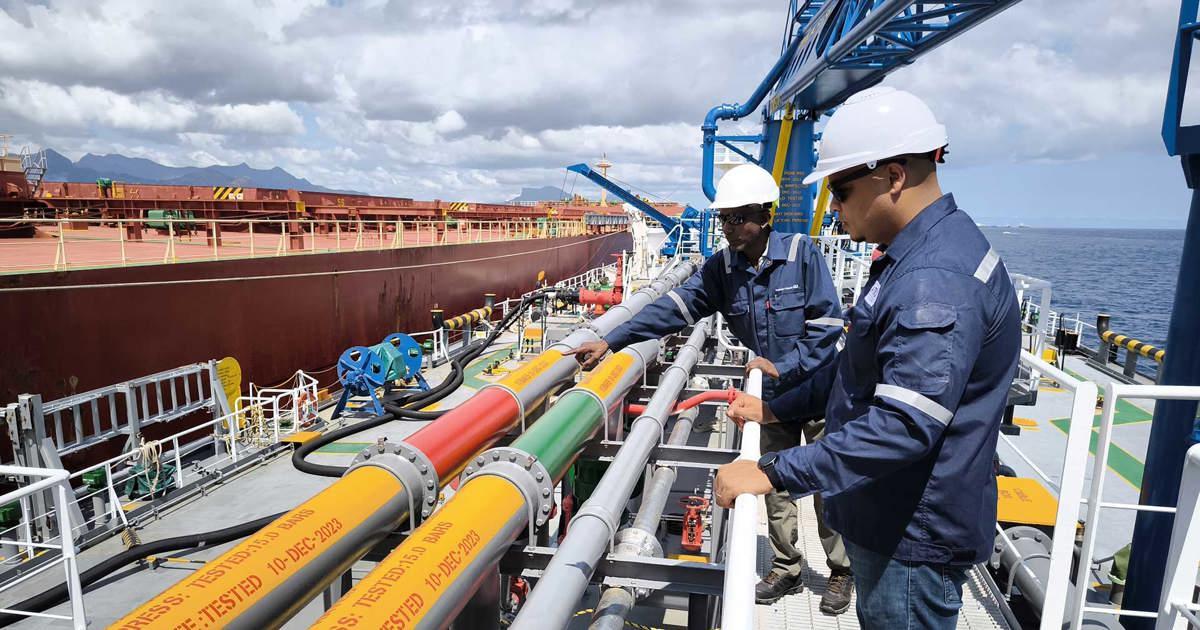 Superintendents inspecting cargo hoses on a tanker deck